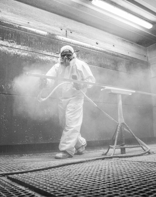 Pracownik w kombinezonie maluje element kuchni ernestrust